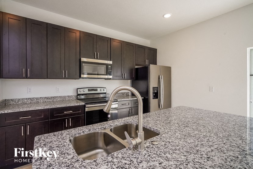 a kitchen with granite counter tops and black and stainless steel appliances