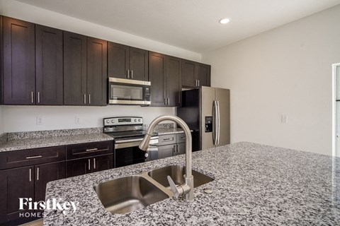 a kitchen with granite counter tops and black and stainless steel appliances