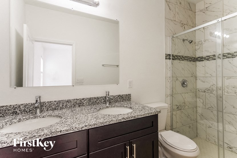 a bathroom with two sinks and a shower and a toilet