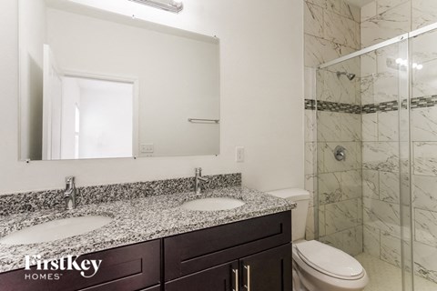 a bathroom with two sinks and a shower and a toilet