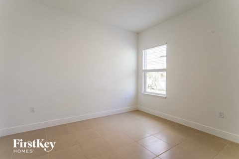 an empty room with a window and a tiled floor