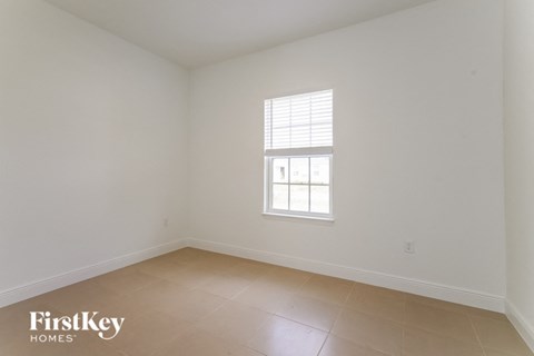 an empty room with a window and a tiled floor