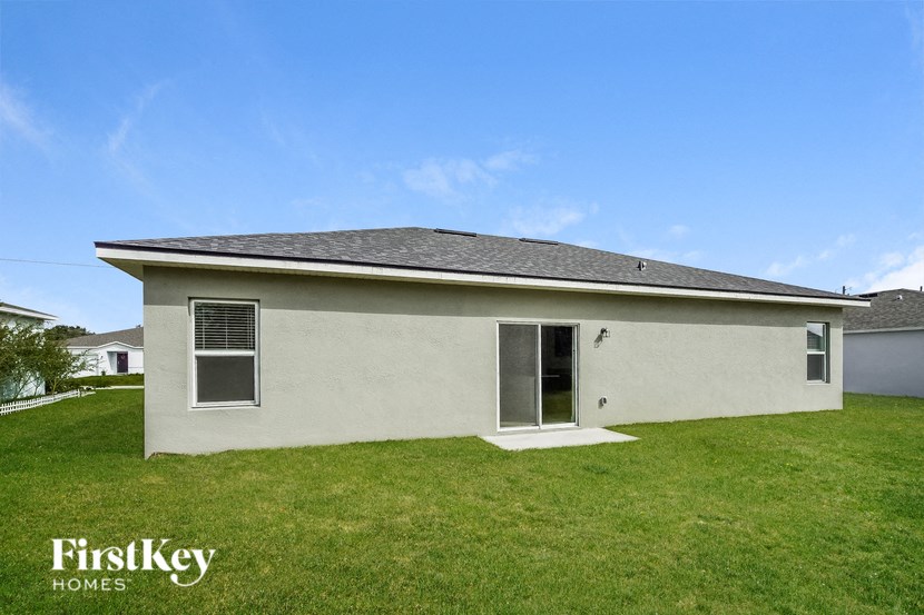 a small white house with a yard and a blue sky