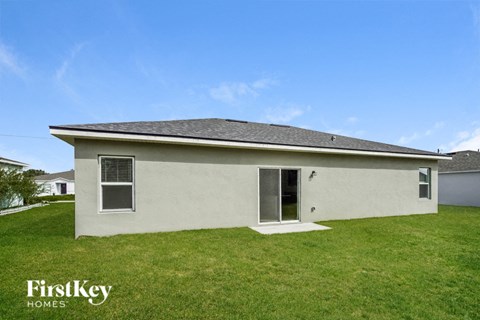 a small white house with a yard and a blue sky