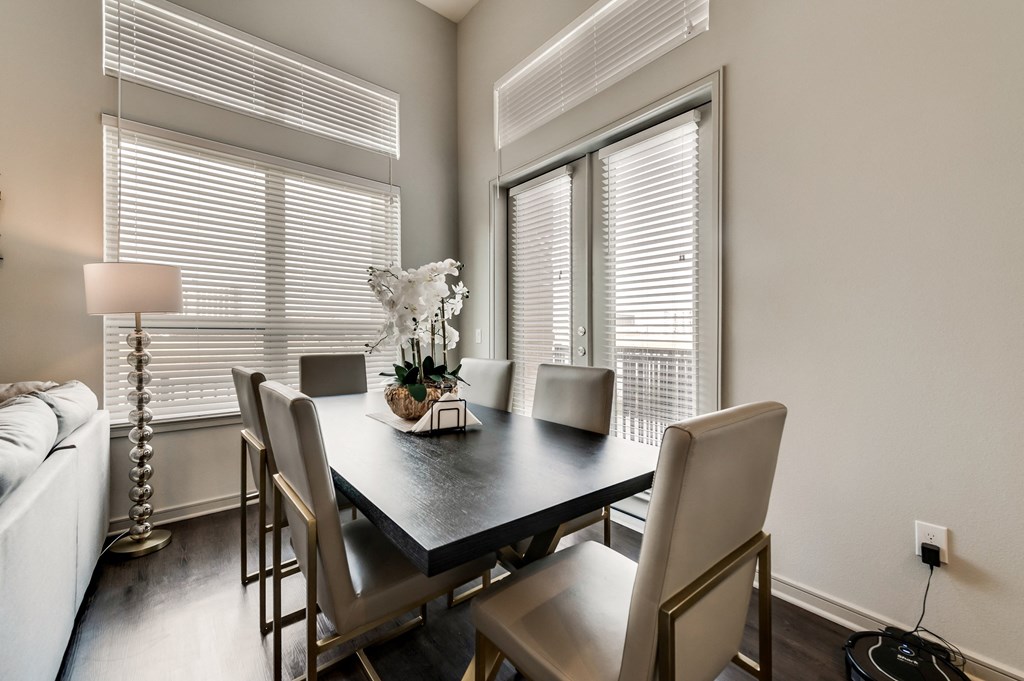 a dining room with a table and chairs and windows