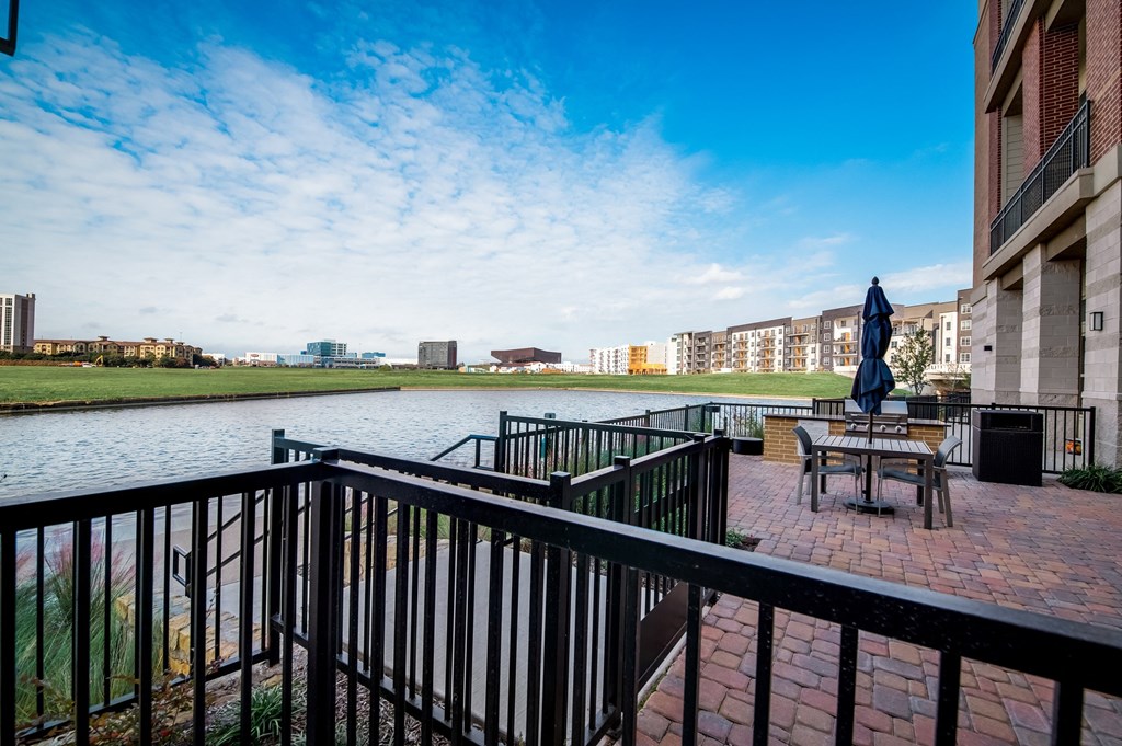 a view of a river from a balcony with a table and an umbrella