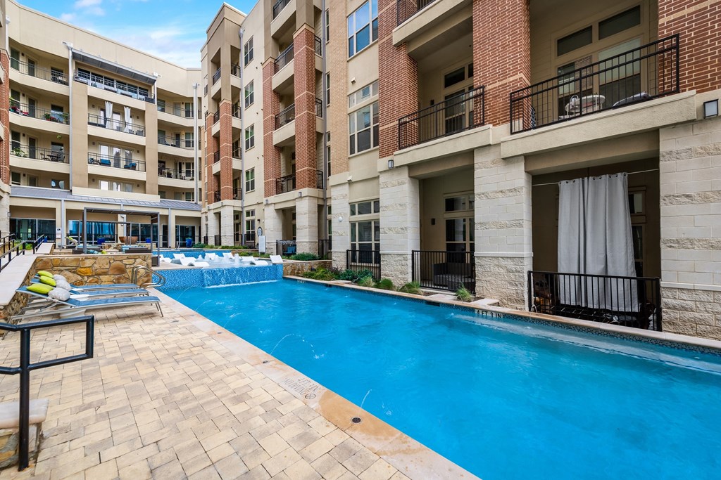a large swimming pool in front of an apartment building