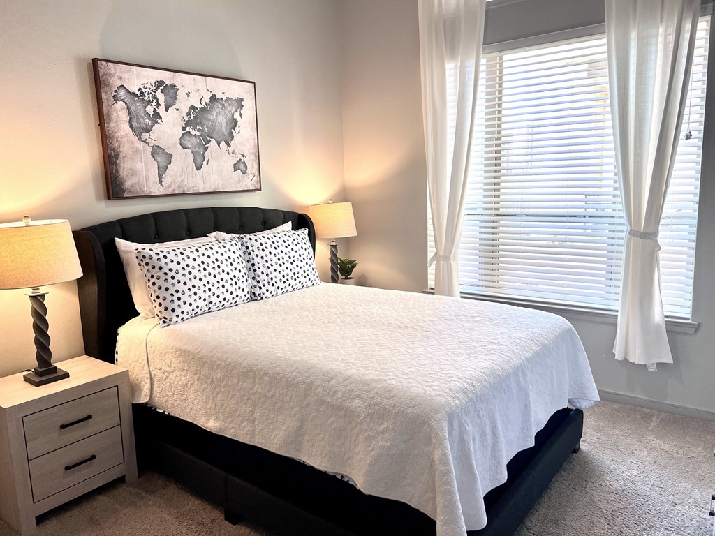 a small bedroom with a bed and two windows