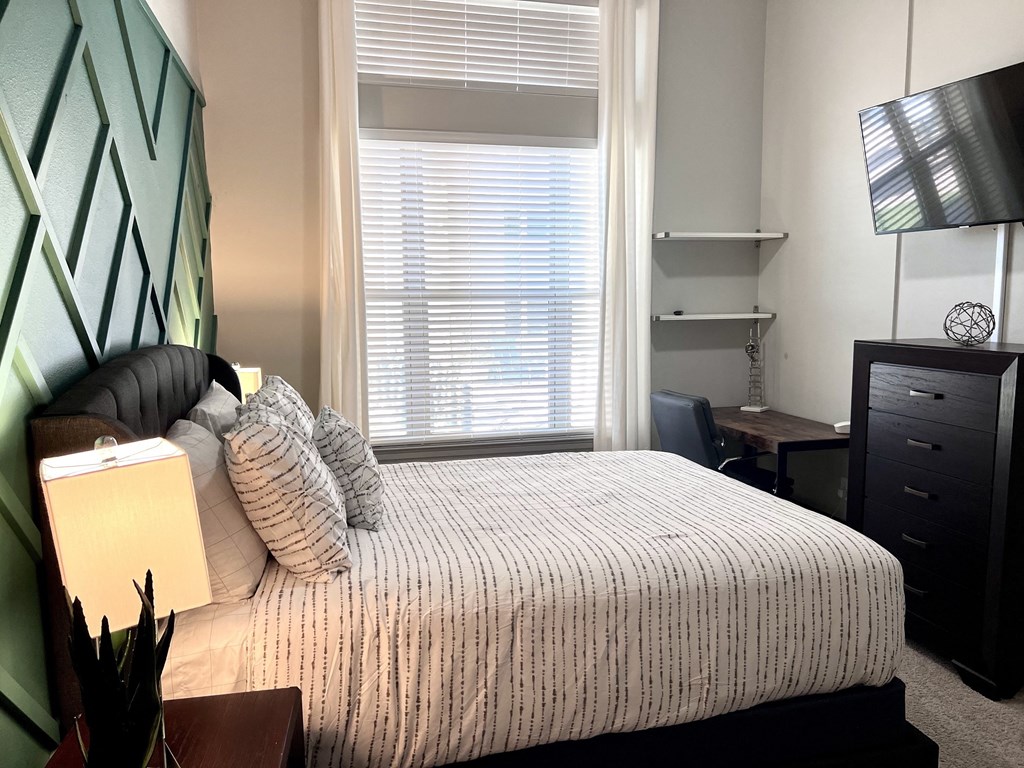 a bedroom with a bed and a large window