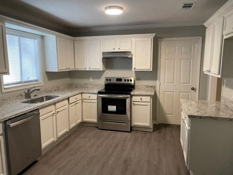 A kitchen with a stove top oven and a sink.