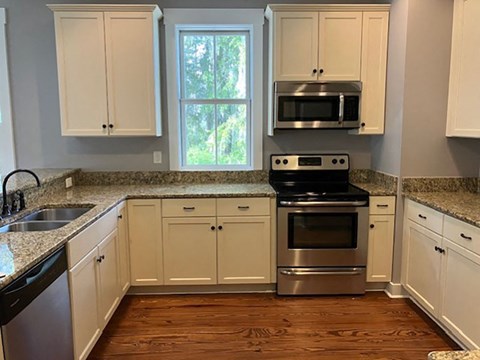 a kitchen with white cabinets and stainless steel appliances