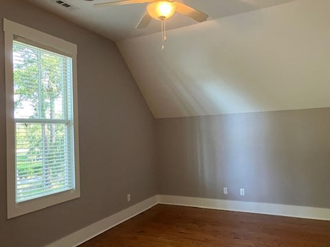 a empty room with a window and a ceiling fan