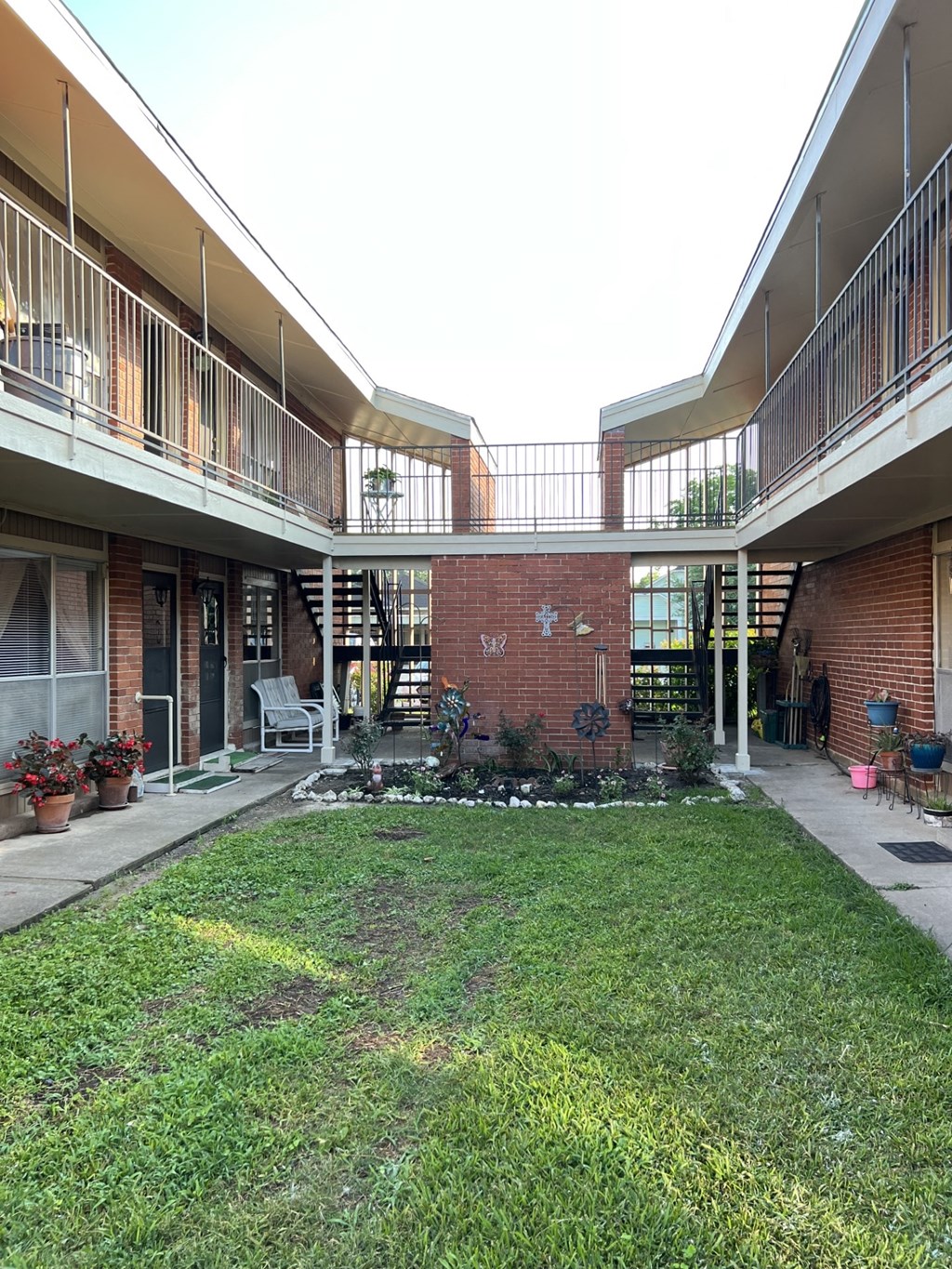 A courtyard with a brick wall and a white bench.