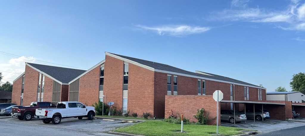 A white truck is parked in front of a red brick building.