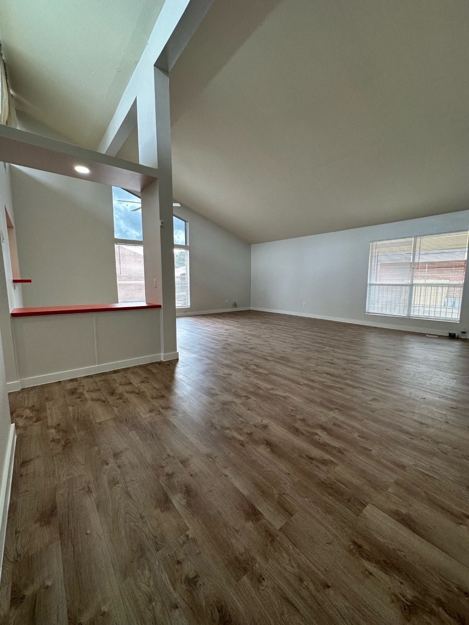 A room with wooden flooring and white walls.