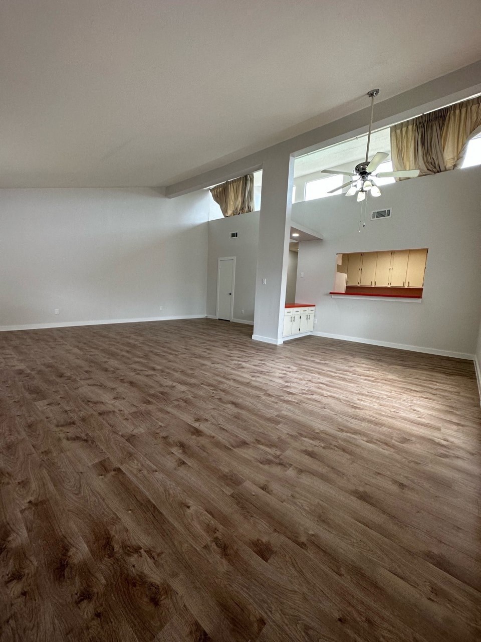 A room with wooden flooring and a ceiling fan.