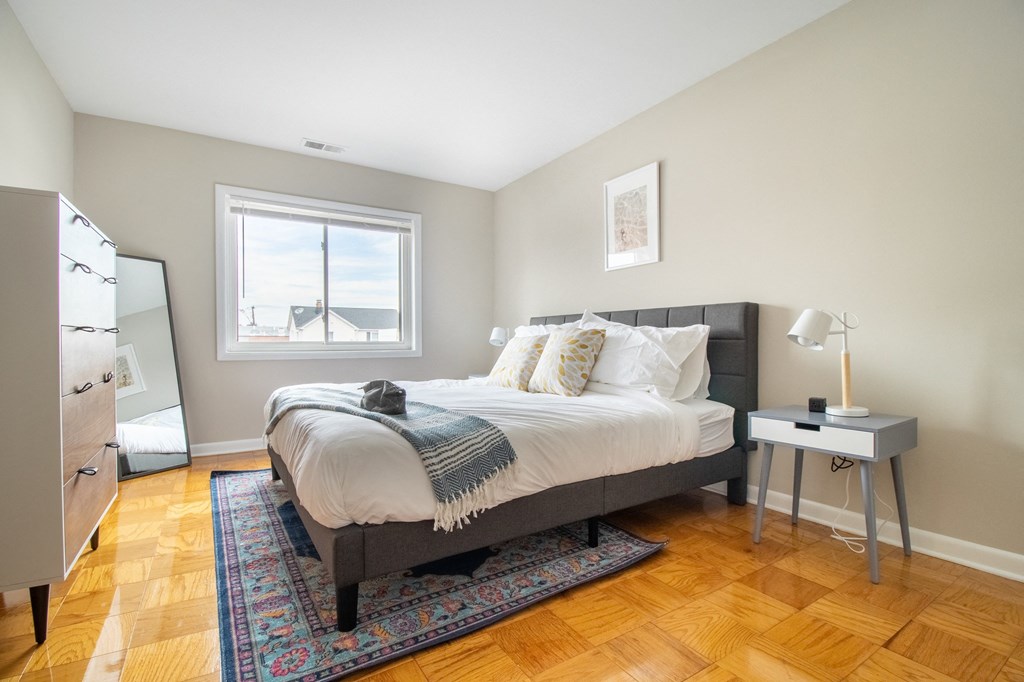 a bedroom with a bed and a dresser and a window