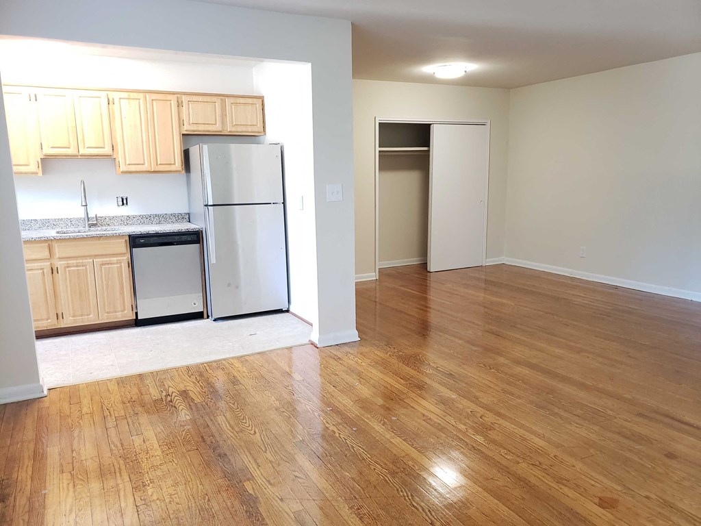 an empty kitchen and living room with a wood floor