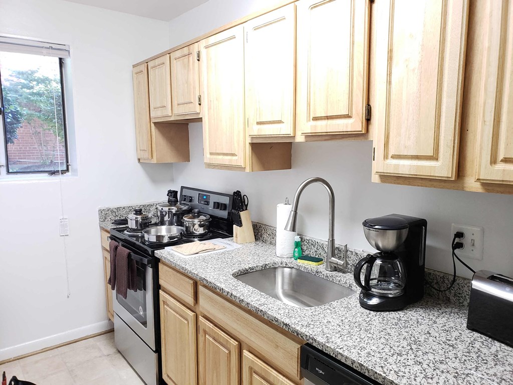 a kitchen with granite counter tops and wooden cabinets