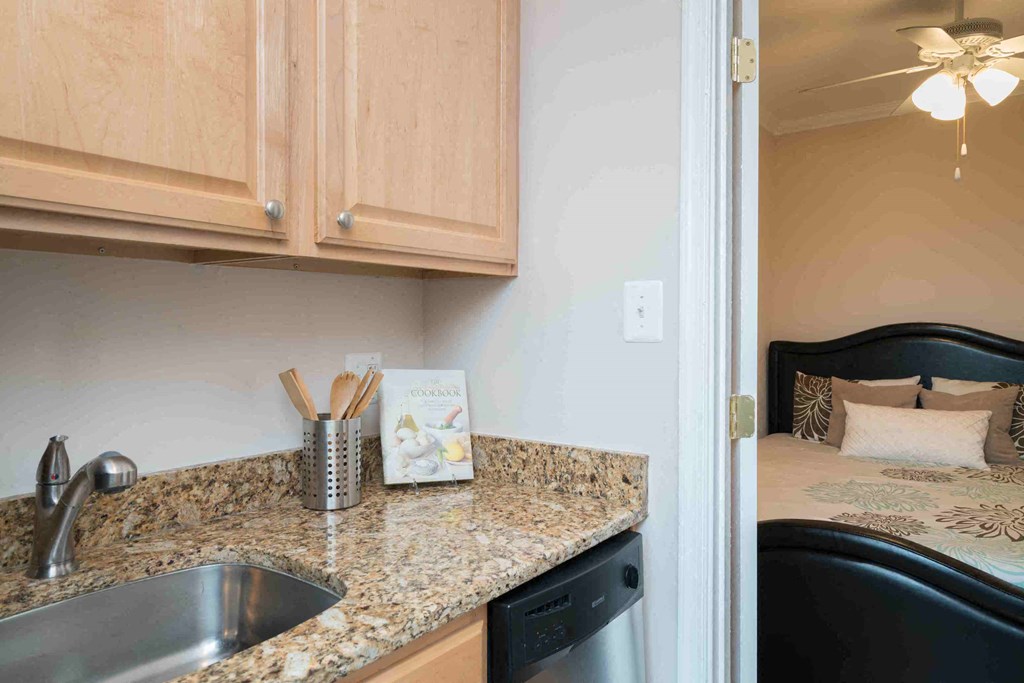 a kitchen with a sink and a counter top and a bed