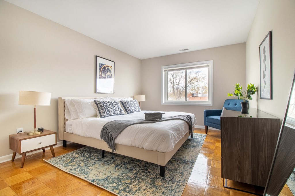 a bedroom with a bed and a dresser and a window