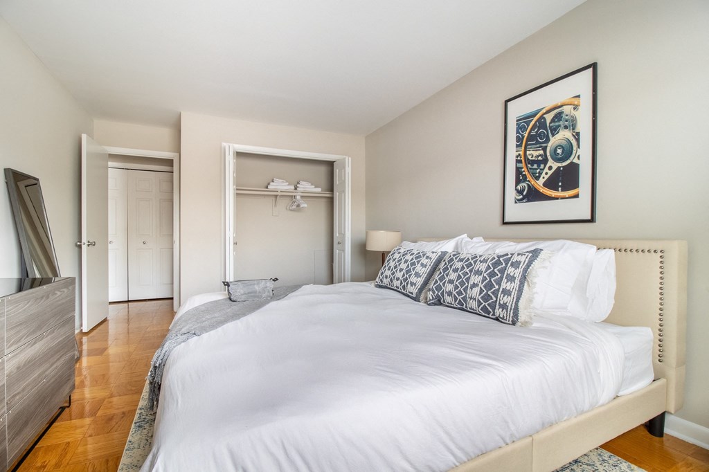 a bedroom with a large white bed and a closet