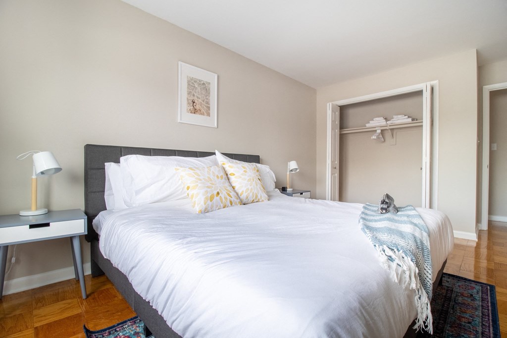 a bedroom with a large white bed and a door to a closet