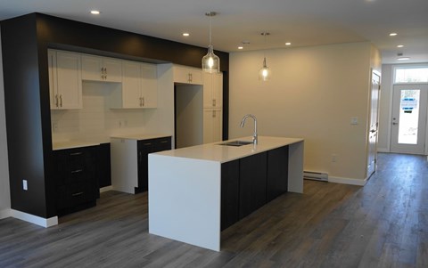 a kitchen with a large white island and black cabinets