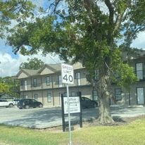 a building with a street sign in front of a tree