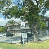 a building with a street sign in front of a tree