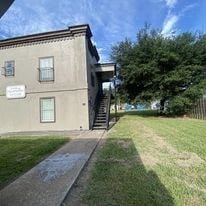 the front of a house with a yard and a tree