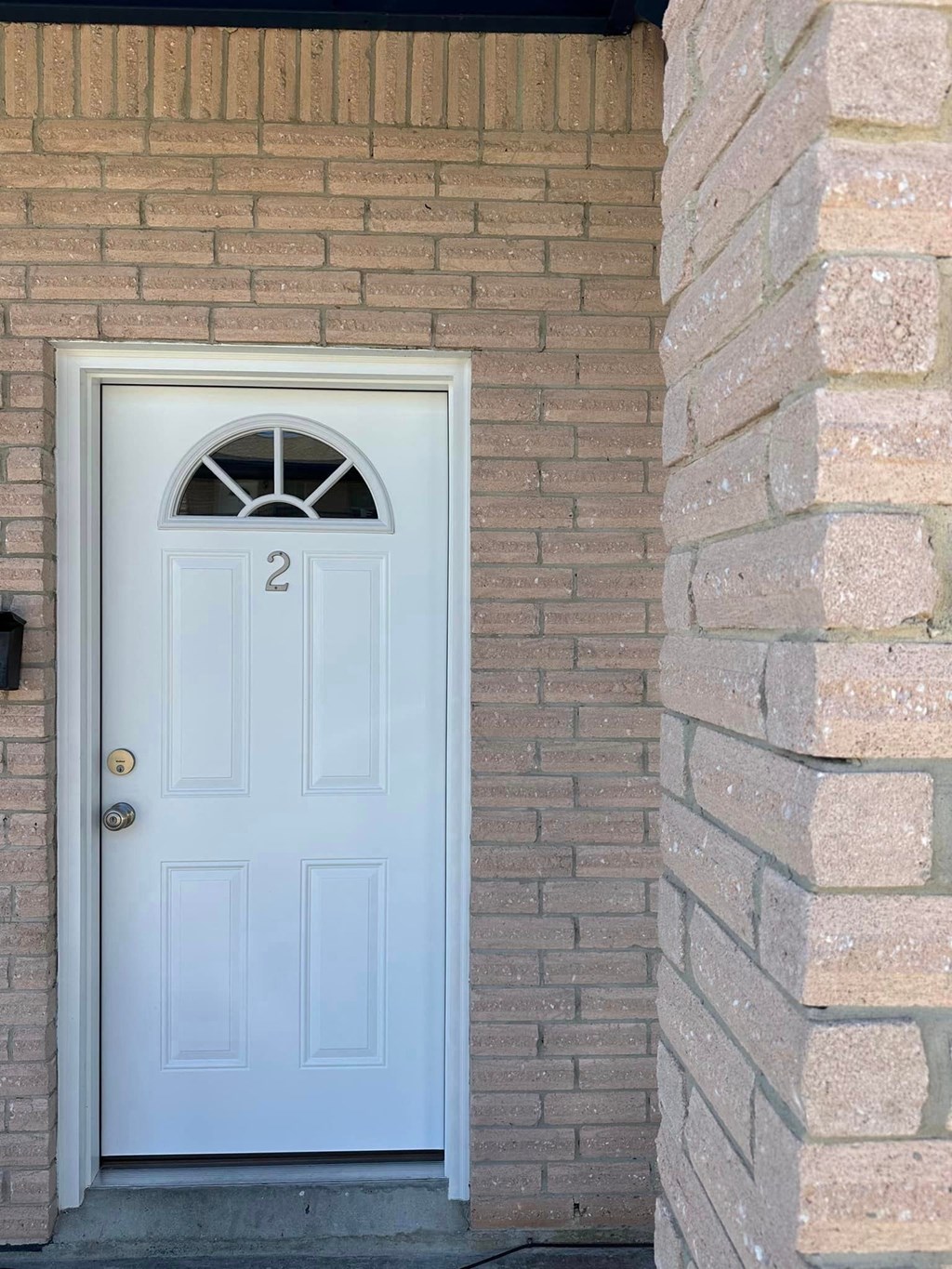 a blue door on the side of a brick building
