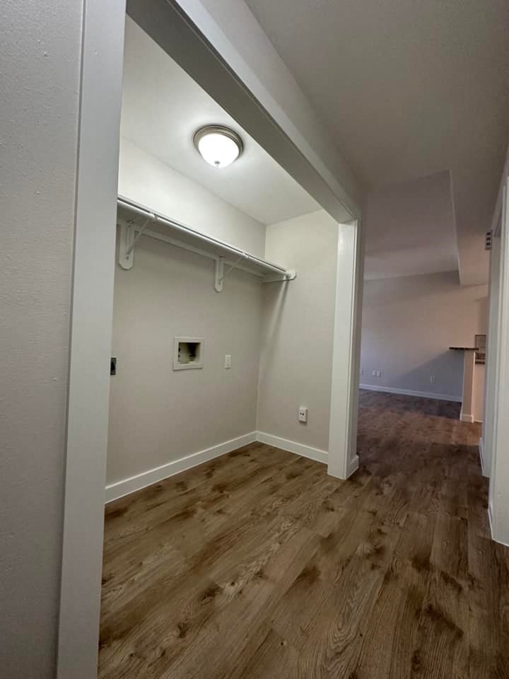 an empty room with white walls and wood floors