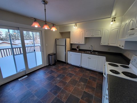 A kitchen with a stove and a refrigerator.