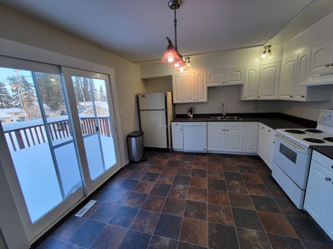 A kitchen with white cabinets and a black stove top oven.