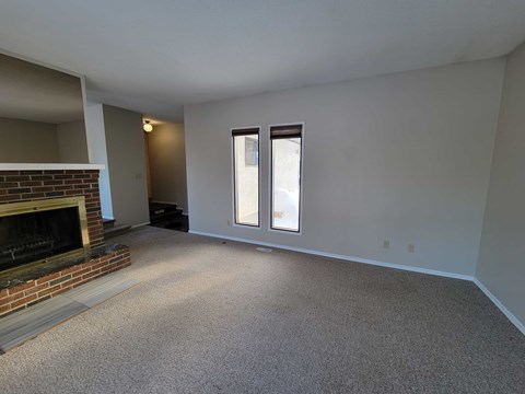 A room with a fireplace and a window.