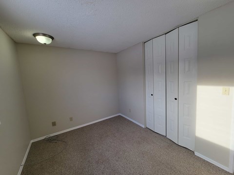 A room with a carpeted floor and a white ceiling with a light fixture.
