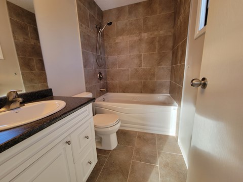 A bathroom with a toilet, sink, and bathtub.