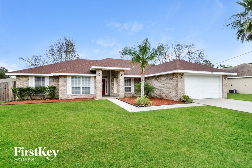 a house with a lawn and a palm tree