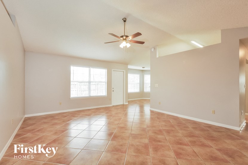 an empty living room with a ceiling fan