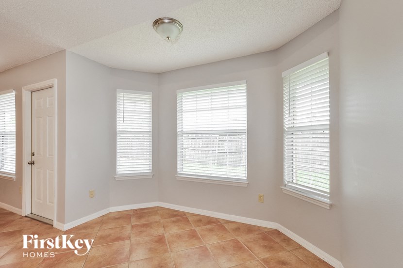 a dining room with three windows and a door