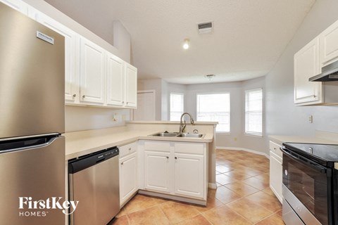 a kitchen with white cabinets and stainless steel appliances and a sink