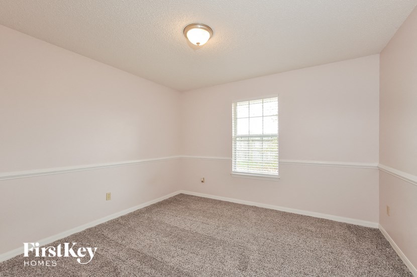 a empty room with carpet and a window