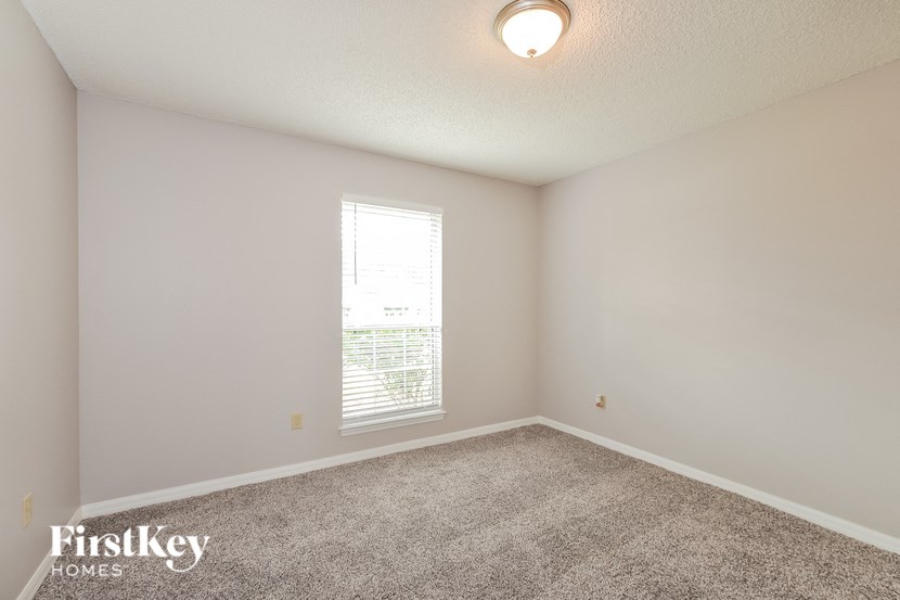 an empty room with carpet and a window