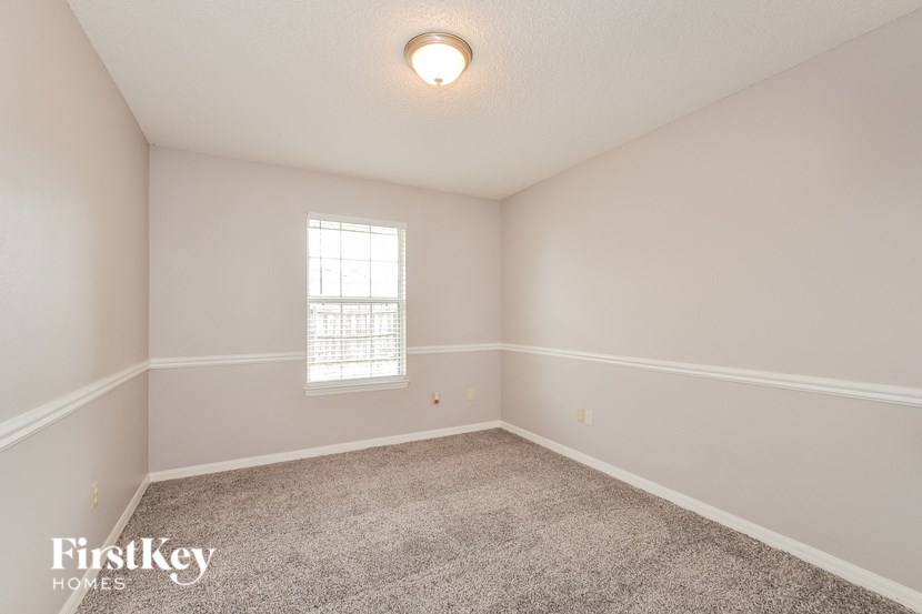 an empty room with carpet and a window