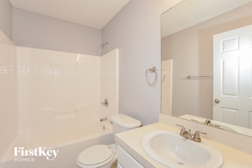 a bathroom with a sink toilet and a mirror