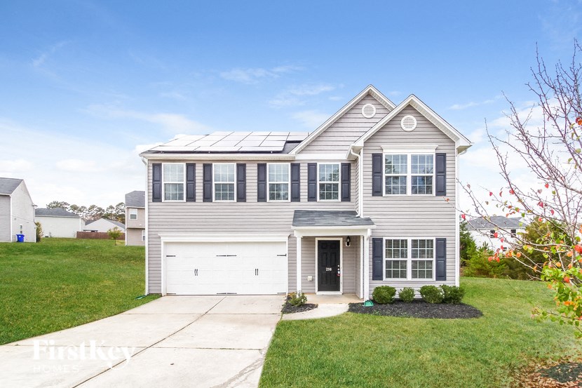 A house with a garage and a driveway in front of it.