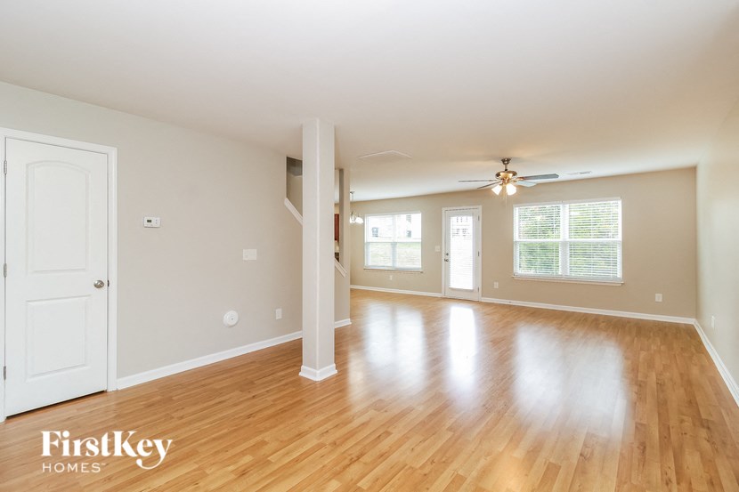 A spacious room with wooden floors and a white door.