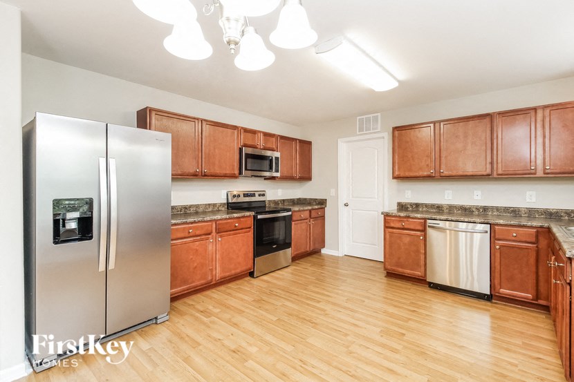 A kitchen with wooden cabinets and a stainless steel refrigerator.