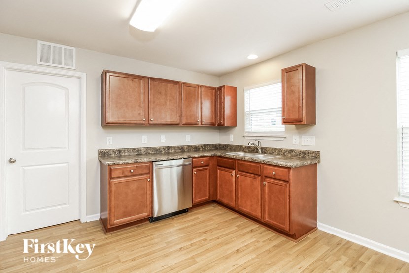 A kitchen with wooden cabinets and a white door.